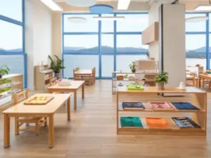 Modern Montessori classroom in 2024 with natural wood furniture, prepared environment, and children engaged in independent learning activities