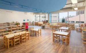 Montessori Infant and Toddler classroom set for ages 0-3 with movement area, practical life materials, sensorial basics, and natural wood child-sized furniture